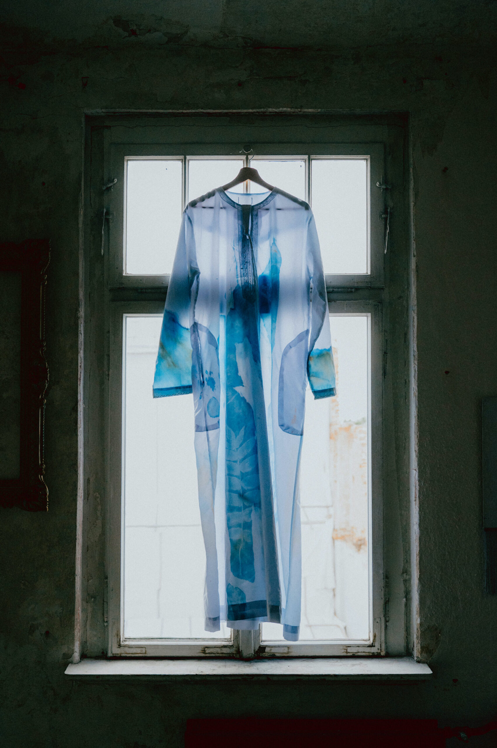 Cyanotype-Nachtgewand geisterhaft im Fenster hängend