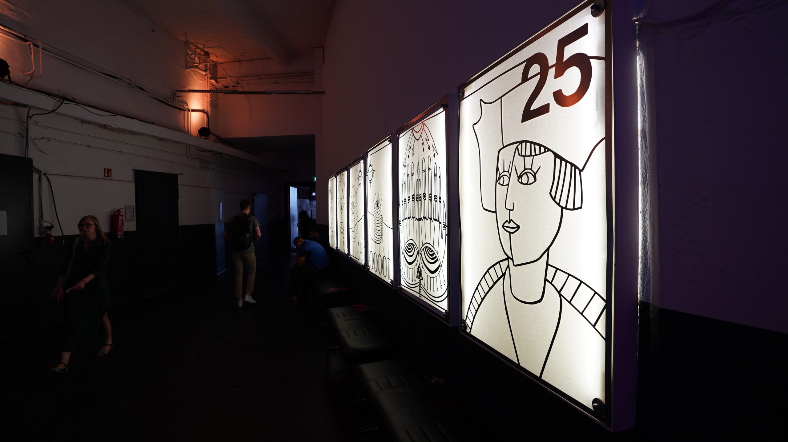 Wand mit Leuchtkästen und Bildern im Glashaus der Arena Berlin