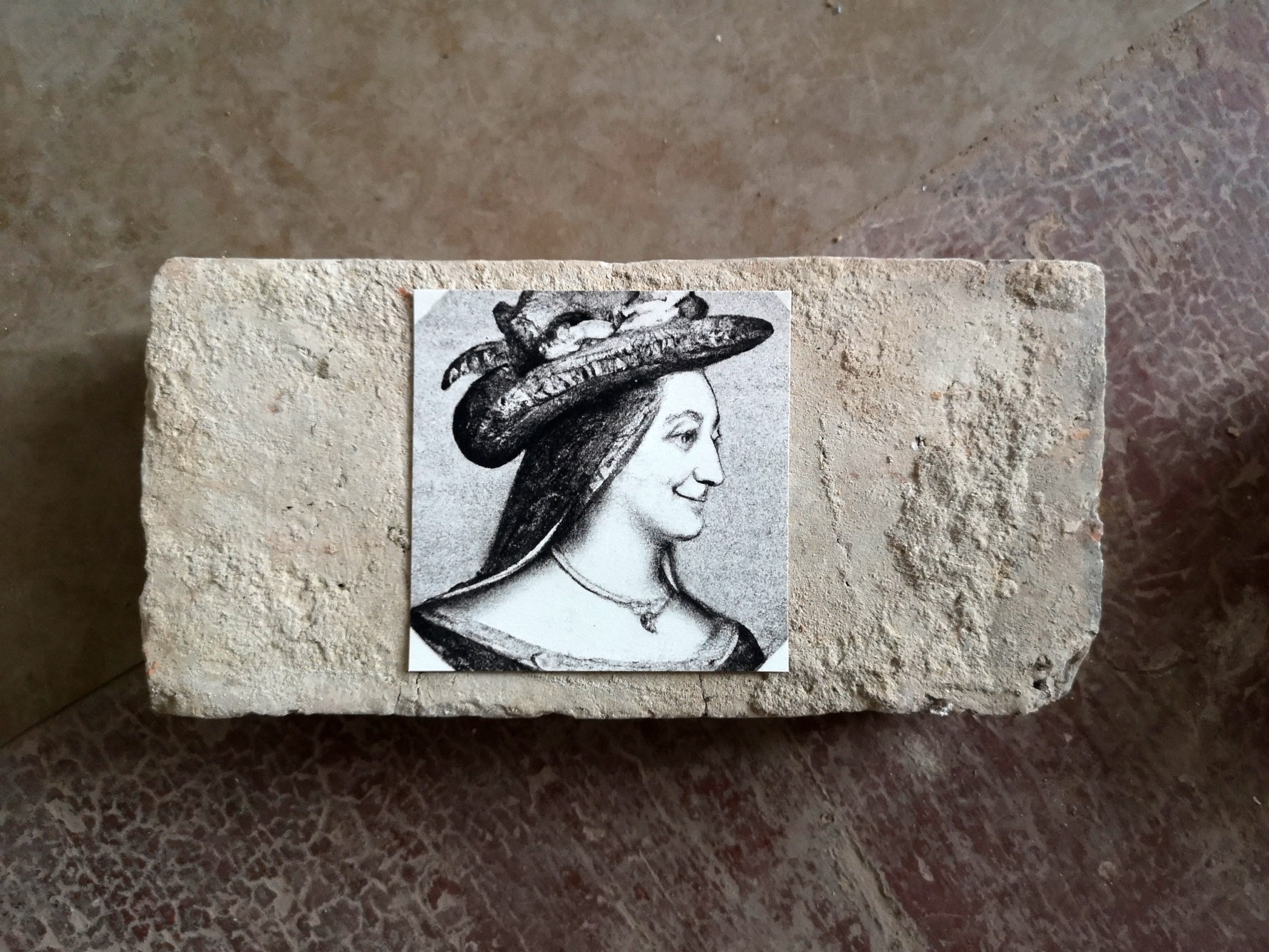 AI-created image of fictitious woman from the past on stone from an old manor house.