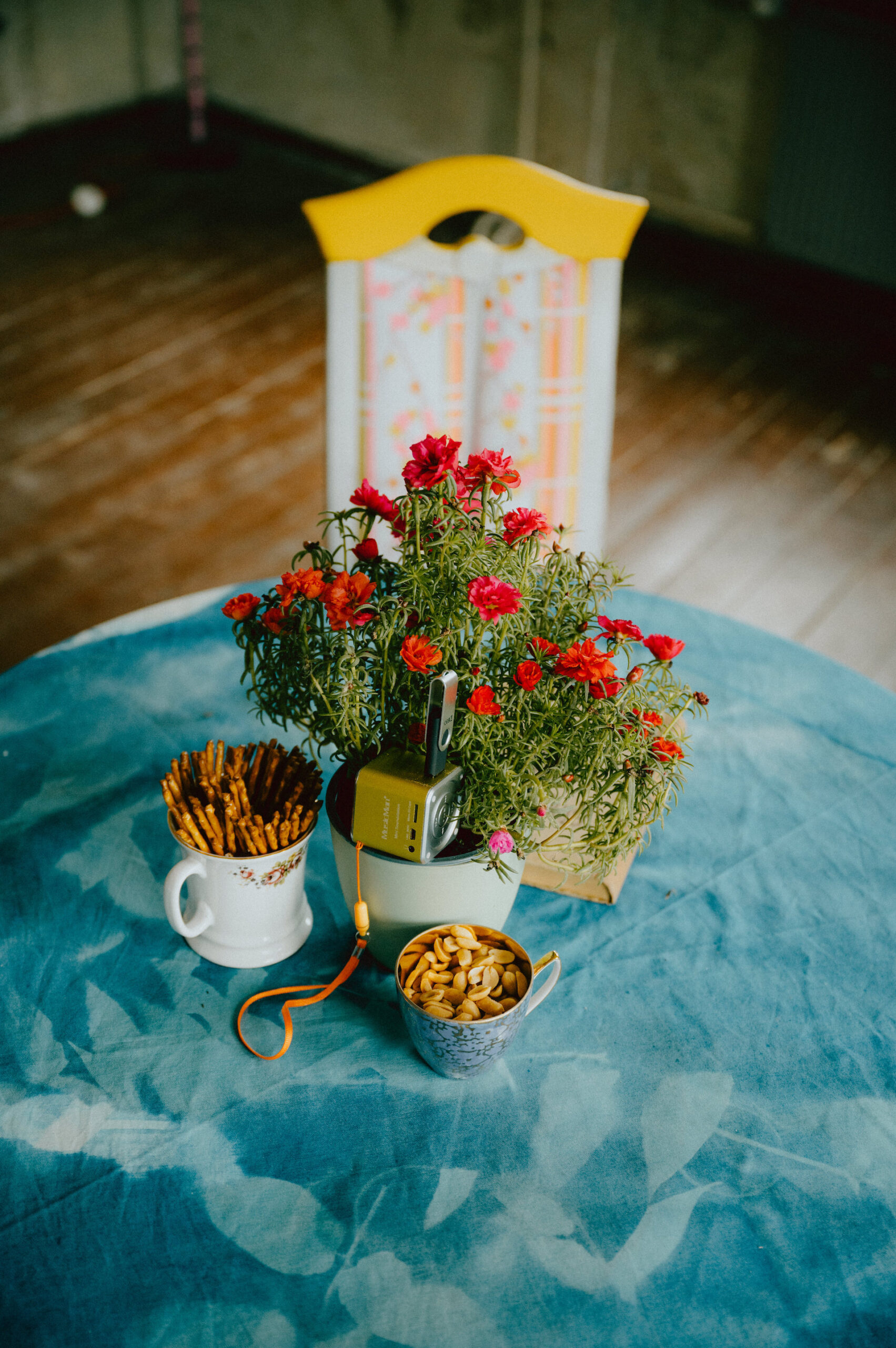 Tisch mit roten Blumen und blauer Tischdecke - Hotel Heimat in Zeitz