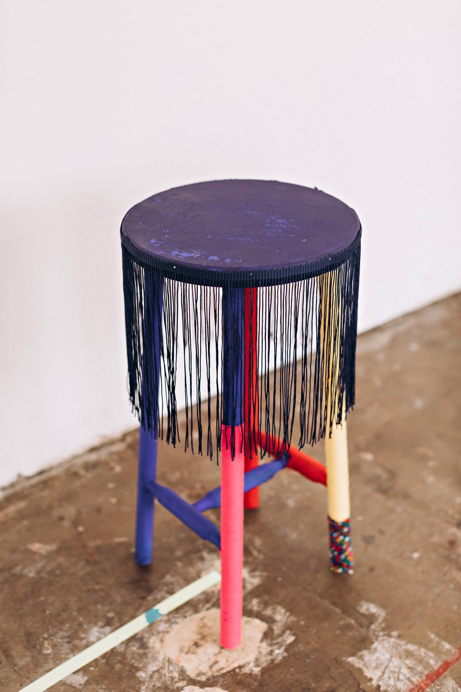 Blau-bunter Hocker mit Fransen in Atelier in Zeitz