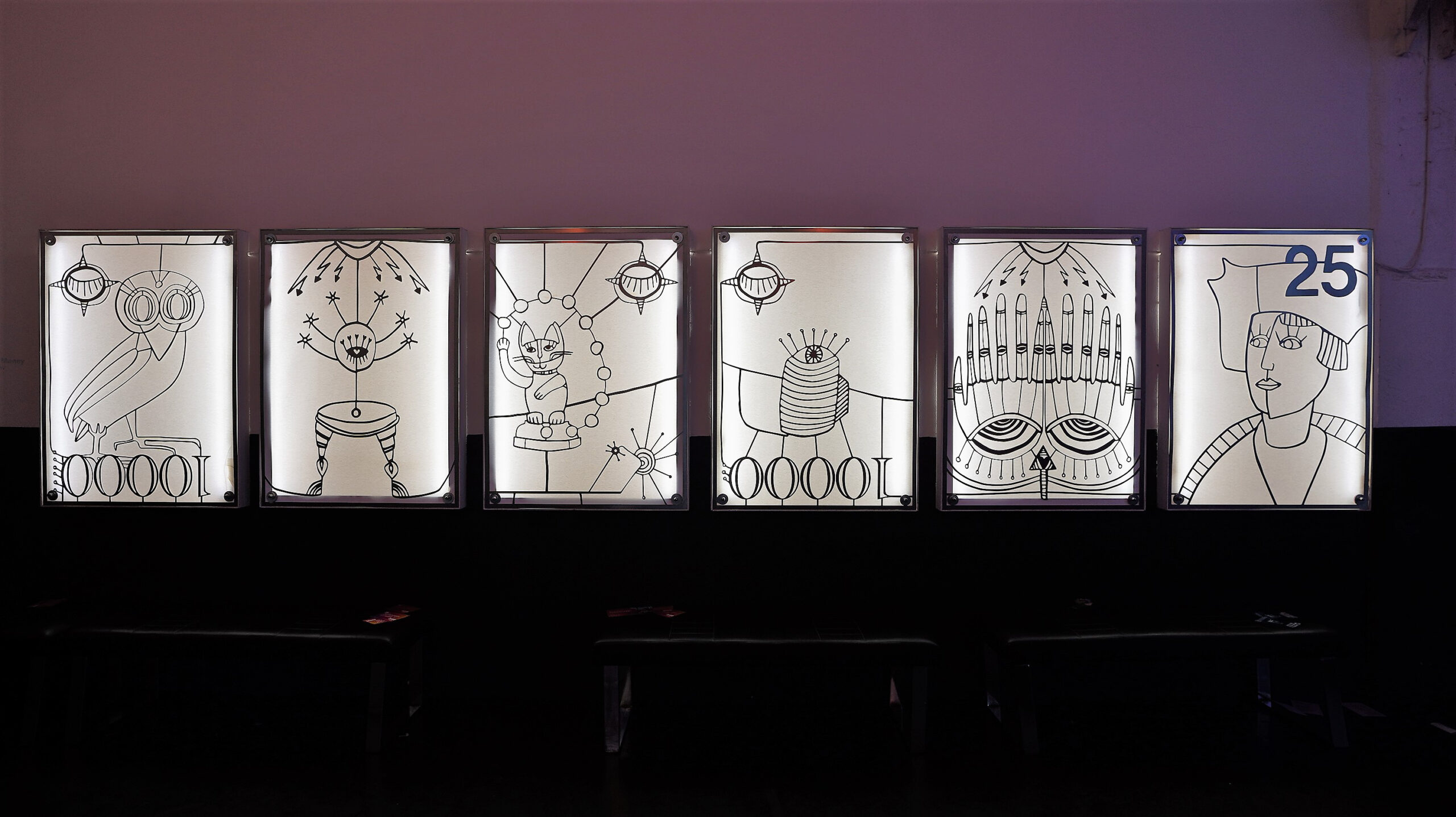 Vier Bilder in erleuchteten Glaskästen im Glashaus der Arena Berlin