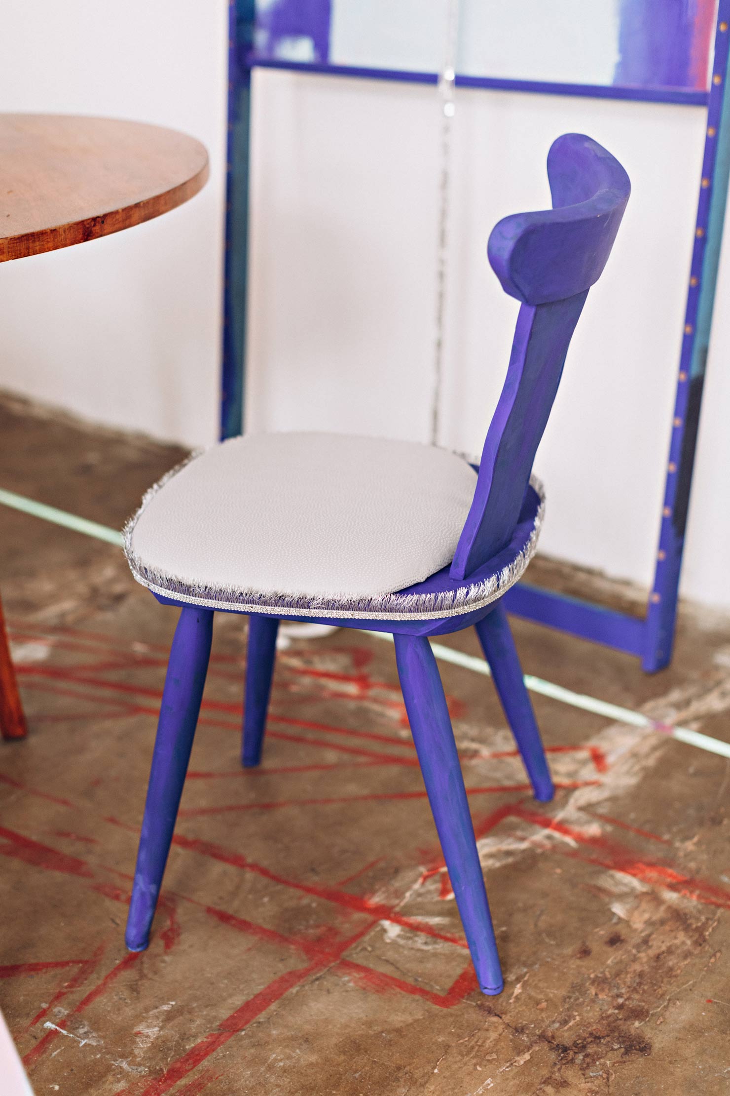 Blauer Stuhl in Kunstatelier mit blauem leeren Rahmen im Hintergrund