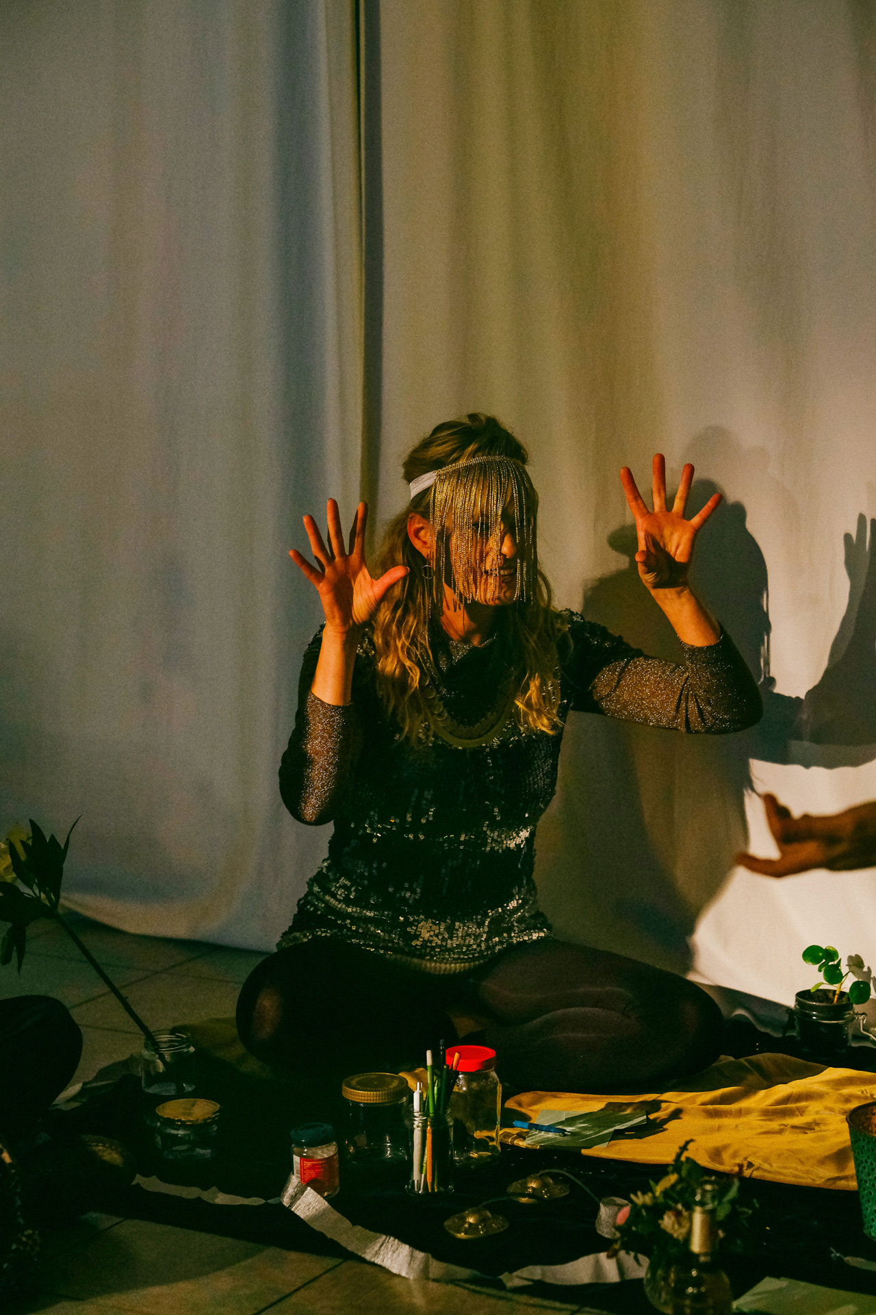 Performance artist holding hands up at a money themed performance in Berlin.