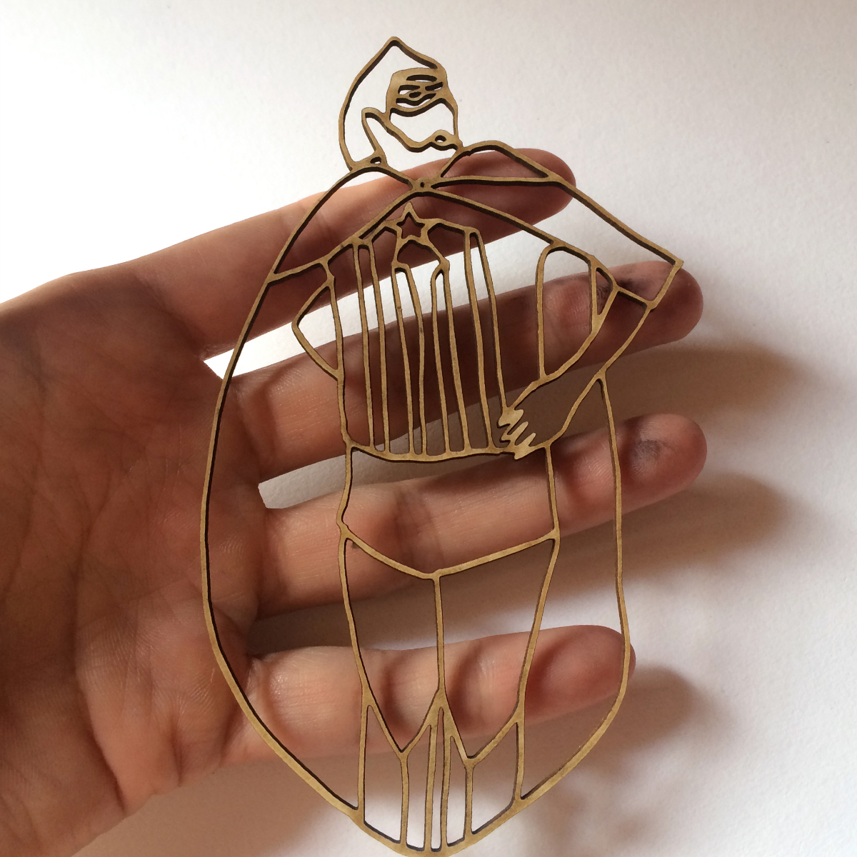 Kleiner Superman aus Papier, gehalten in der Hand