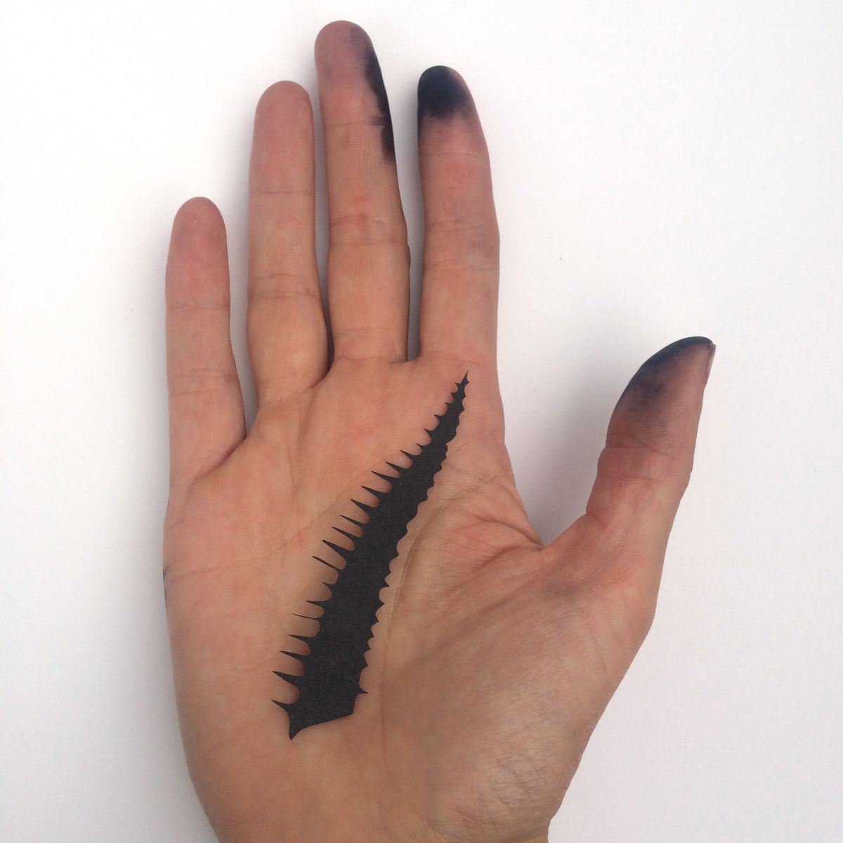 Hand mit schwarzer Fingerkuppe und abstraktem Horn