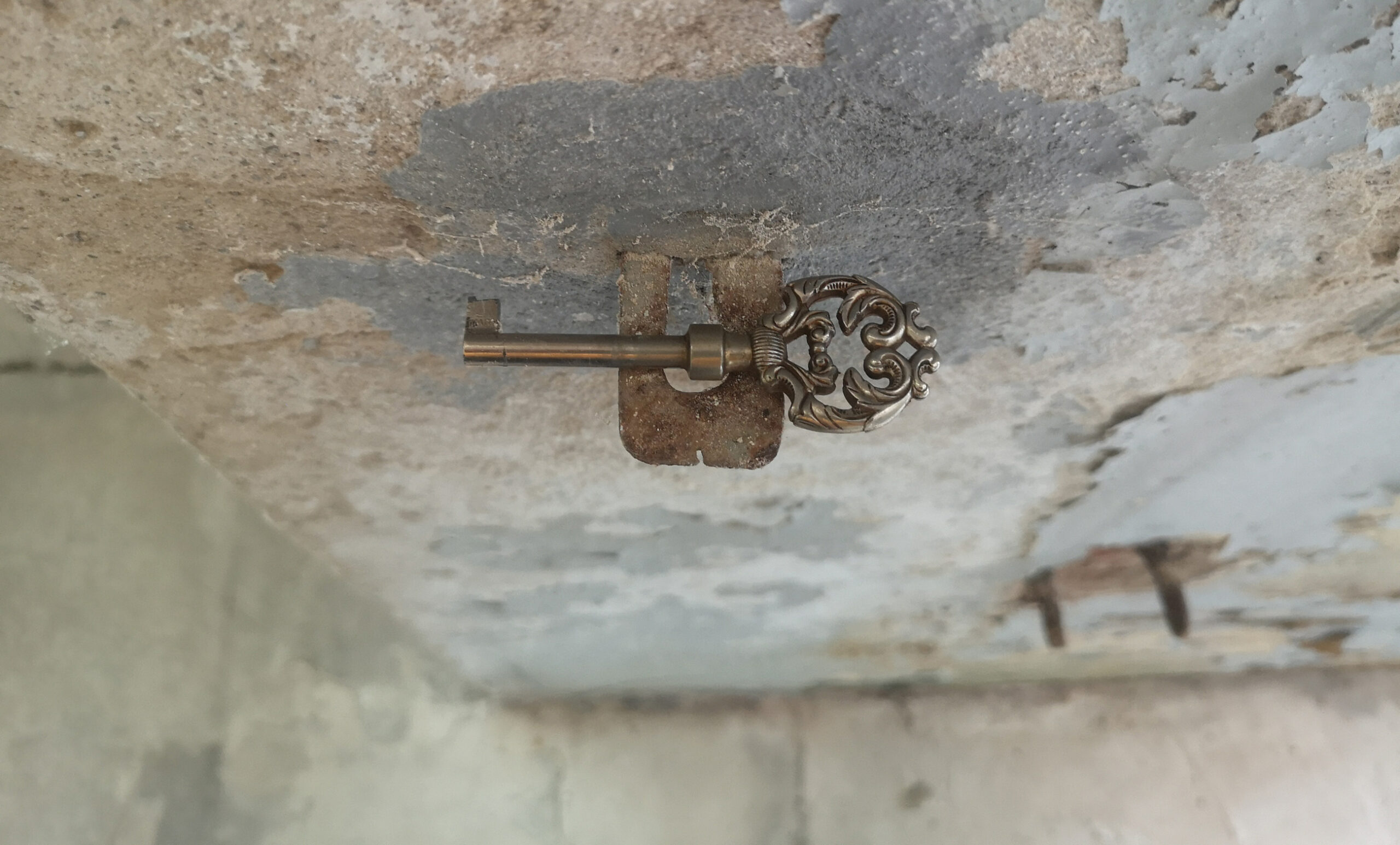 Historischer Schlüssel vor Wand mit Patina