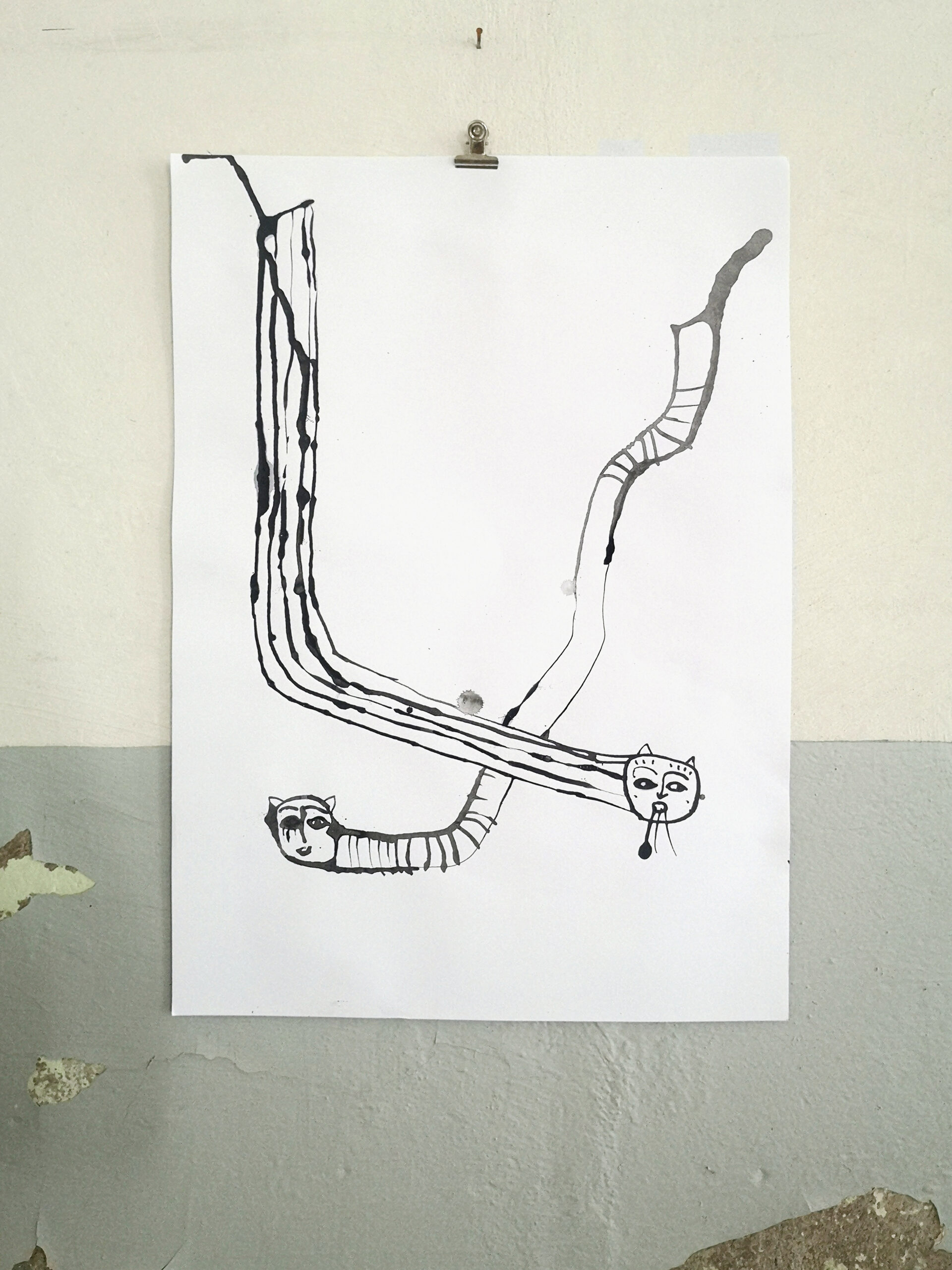 Künstlerische Tintenzeichnung zweier schlangenartiger Wasserspeier mit Antenne vor alter Wand.